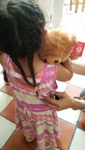 Immigrant girl hugging teddy bear